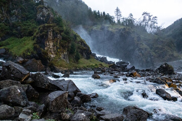 Latefossen Waterfall, unique waterfall epic powerful side rock lightened in dark. Twin waterfall in...