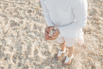 Little cute girl searching seashells on the sea beach