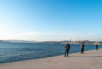 People fish from the Bosphorus. Fisherman fishing over bosphorus. Men fishing in Istanbul Strait.
