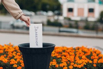 Woman throws sheet with word depression into trash can. Psychology help
