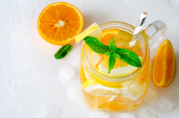 Summer refreshing iced drinks with orange, lemonand mint on white background