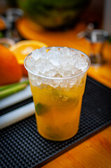 Cocktail preparation with orange, mint, maracuja and ice.