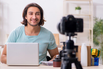 Young male shopaholic recording video for his blog