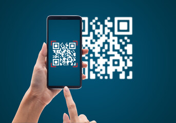 Hand using mobile smart phone scan Qr code on blue background. Cashless technology and digital money concept. - obrazy, fototapety, plakaty