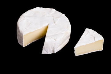 pieces of soft cheese Camembert on dark blackbackground. Delicious pieces of white mold cheeses with soft textures Camembert close up, macro