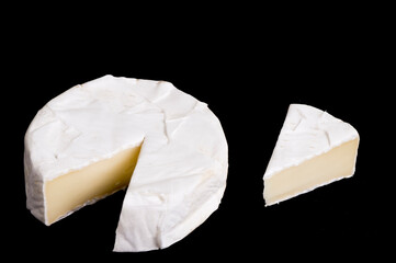 pieces of soft cheese Camembert on dark blackbackground. Delicious pieces of white mold cheeses with soft textures Camembert close up, macro