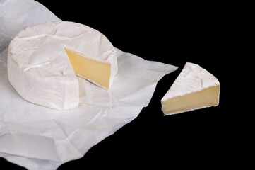 pieces of soft cheese Camembert on dark blackbackground. Delicious pieces of white mold cheeses with soft textures Camembert close up, macro