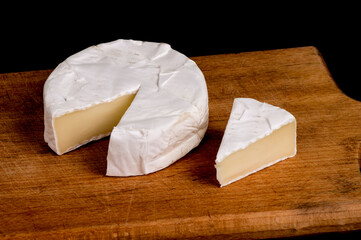 pieces of soft cheese Camembert on dark blackbackground. Delicious pieces of white mold cheeses...