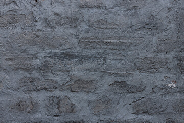 Dark grey brick wall texture with old plaster. Retro building background copy space. Monochrome surface, detailed stones backdrop. Desktop wallpaper textured screensaver front view. Text design mockup
