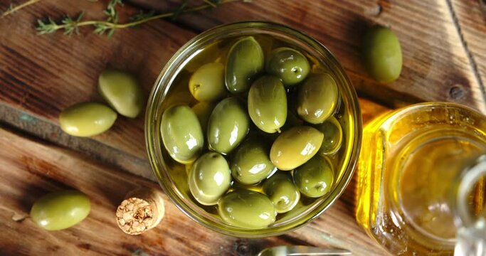 Olives with olive oil on table slowly rotating.