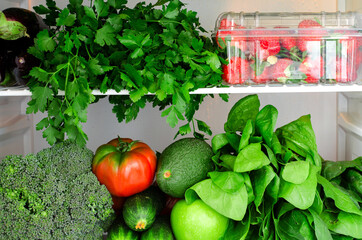 Greens, fruits and vegetables in fridge. Vegan, raw, healthy lifestyle concept