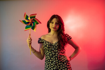 Young beautiful caucasian woman indoor studio shot holding pinwheel - wind power, alternative...