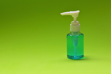 Disinfecting hand gel on green background, space for text