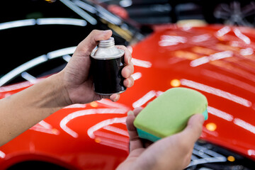 Car service worker applying nano coating on a car detail