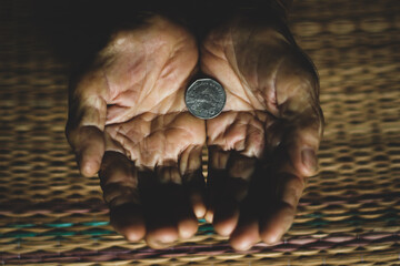 One coin in old hand palm