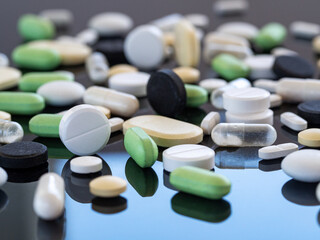 Medicines for various diseases in bulk on a mirror background. Medical background for business, industry, pharmacies, clinics, hospitals.