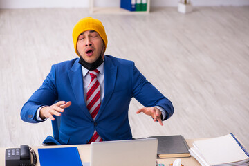 Sick male employee suffering at workplace from coronavirus