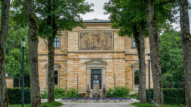 Elegantes klassisches Sandsteingeb&auml;ude mit Skulptur vor der Eingangst&uuml;r mit einer kleinen Laubbaum Allee im Vordergrund. Haus Wahnfried Bayreuth in Bayern, Deutschland.