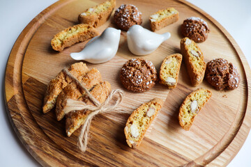 Traditional italian cantuccini cookies with almonds and dried cranberries with a glass of red sweet wine on a wooden background. Home baking concept.