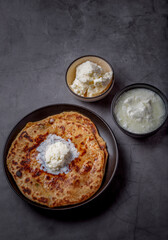 Aaloo parantha or stuffed potato flatbread with curd and white butter