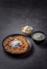 Aaloo parantha or stuffed potato flatbread with curd and white butter