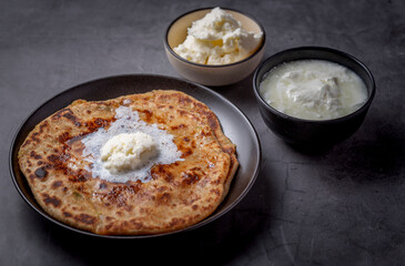 Aaloo parantha or stuffed potato flatbread with curd and white butter