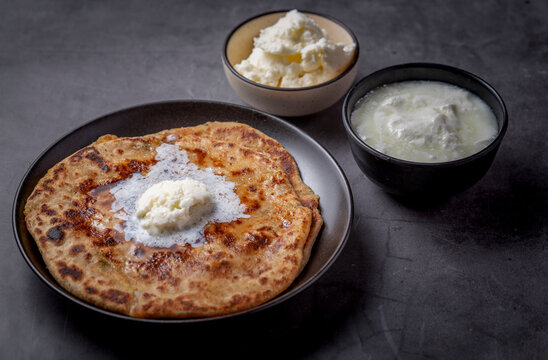 Aaloo parantha or stuffed potato flatbread with curd and white butter