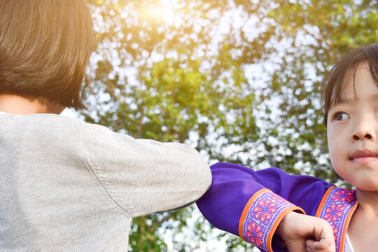 Social distancing. Two children bump elbows new novel greeting. Friends demonstrating to avoid the spread of coronavirus.
