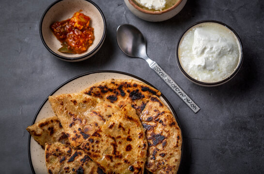 Aaloo parantha or stuffed potato flatbread with curd, pickle and homemade white butter