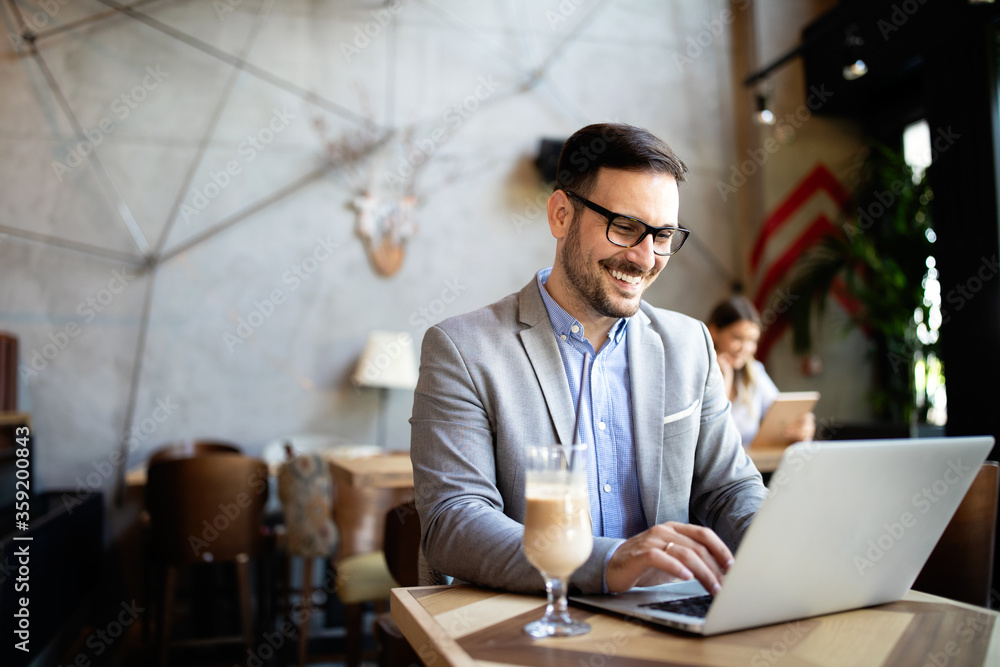 Wall mural happy confident businessman working, using laptop in office