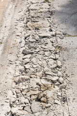 Broken Road crack Texture. After Construction drilled surface with jackhammer. Concrete broken from excavator drilling. The road was dug and drilled to create drainage ditches.