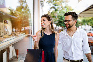 Consumerism, love, dating, travel concept. Couple enjoying shopping having fun