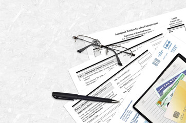 USCIS form I-586 Immigrant petition by Alien Entrepreneur lies on flat lay office table and ready...