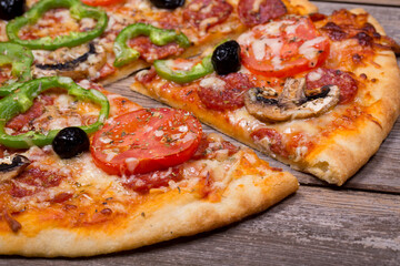 Pizza with a variety of topping on ole wood background