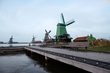 Fototapeta premium Autumn holland village pier with bench and windmills