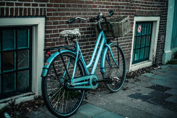 A vintage bike rests against a brick wall