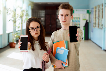 Bored student receive notification with bad information showing screens of their phones to the...