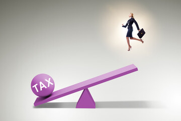 Businesswoman in tax concept with seesaw