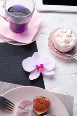 life style concept.Thai blue, Butterfly pea tea served with fresh figs and panna cotta cake and fruit piece of cake on serving napkins.