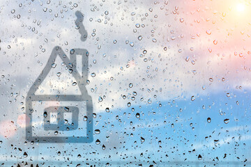 House painted on misted glass. Window glass with raindrops against the blue sky. - 359209026