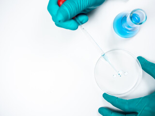 Chemical dropper tube That has blue chemicals inside Dripping on petri dish There is a scientist's...