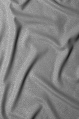 Black and white wavy silk fabric with folds. Mockup and blank designer for making a flag on a gray background.