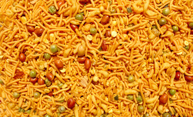 Indian mix snack, deep fried salty dish - chivda made of flour, mixed with roasted nuts, pepper, pulses, spice and green peas. Bombay mix