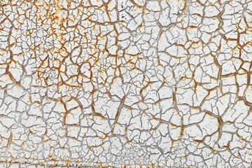 White cracked paint is applied to a rusty surface