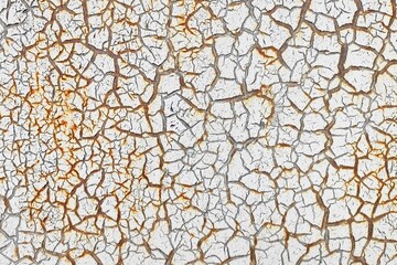 White cracked paint is applied to a rusty surface