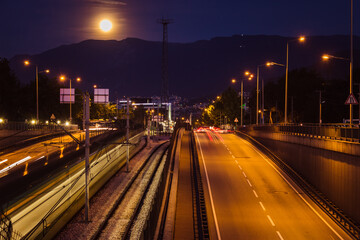 Fototapeta na wymiar Bursa night city view. Mudanya highway and subway station. Traffic lights, Uludag mountain and full moon landscape.