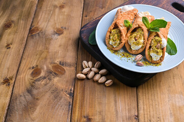 Cannoli Sicily. Traditional Italian sweet with ricotta and various fillings. Food on a wooden cutting board. Delicious treats from the south of Italy. Copy space
