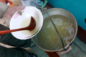 Person pouring russian fish soup