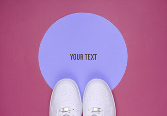 White sneakers on pink background with blue pastel circle for copy space. Youth hipster concept. Top view
