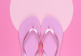 Pink flip flops on pink background with pink pastel circle for copy space. Minimalistic vacation on the beach concept. Summer time. Top view